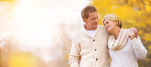 Happy retired couple enjoying a fall day after speaking with their Barrie Financial Advisor